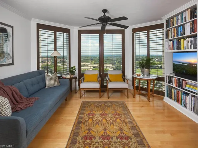 Living room featuring ceiling fan, crown molding, and light wood-type flooring