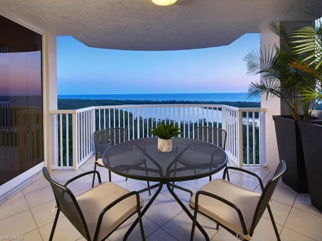 Balcony at dusk featuring a water view