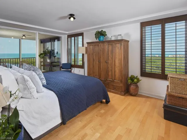 Bedroom with a water view, light hardwood / wood-style flooring, access to exterior, and crown molding