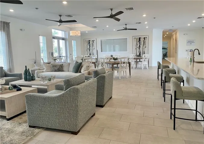 Living room with crown molding, sink, light tile patterned floors, and ceiling fan