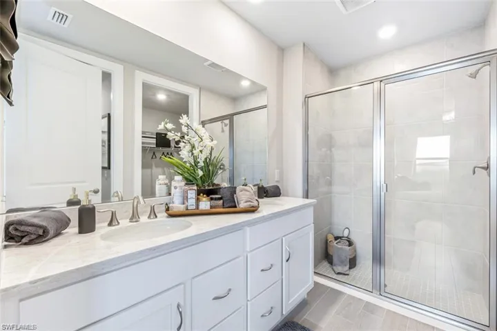 Bathroom with vanity and a shower with shower door
