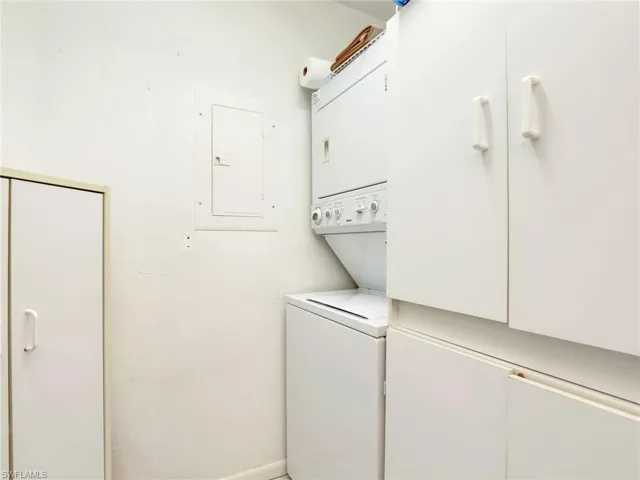 Washroom with electric panel and stacked washing maching and dryer