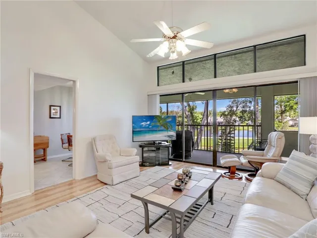 Living room featuring light hardwood / wood-style flooring, high vaulted ceiling, and ceiling fan