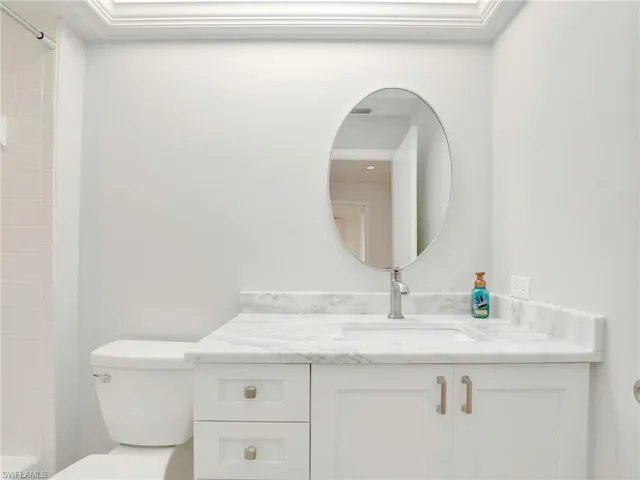Bathroom with vanity, a shower, and toilet
