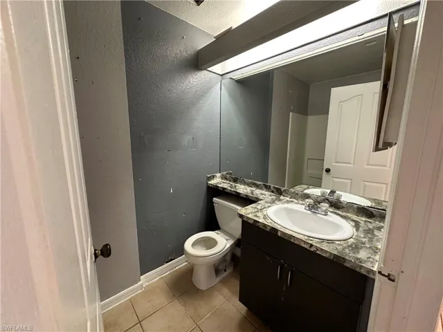 Bathroom with vanity, tile patterned flooring, and toilet
