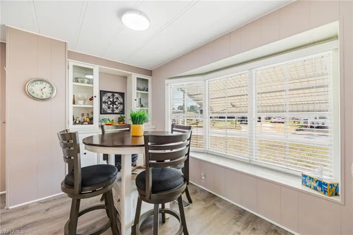 Dining space featuring wooden walls, built in shelves, light wood-style floors, and a decorative wall