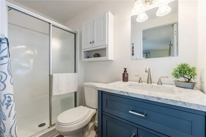 Full bath with a stall shower, vanity, and a chandelier