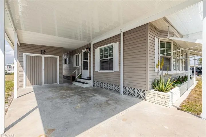 View of patio featuring an attached carport, entry steps, and driveway