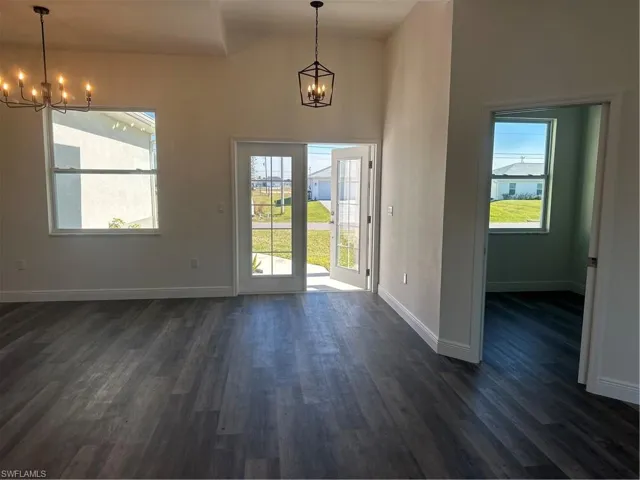 Doorway with dark hardwood / wood-style flooring and a chandelier