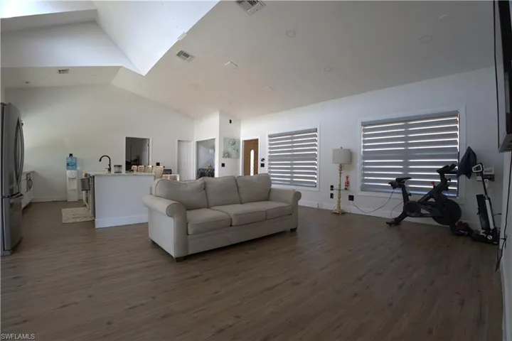 Living room with dark wood-style floors and high vaulted ceiling