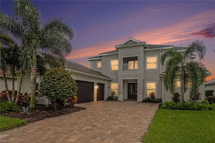 TWILIGHT PHOTO OF FRONT OF HOME.  3-CAR GARAGE IS AT LEFT.