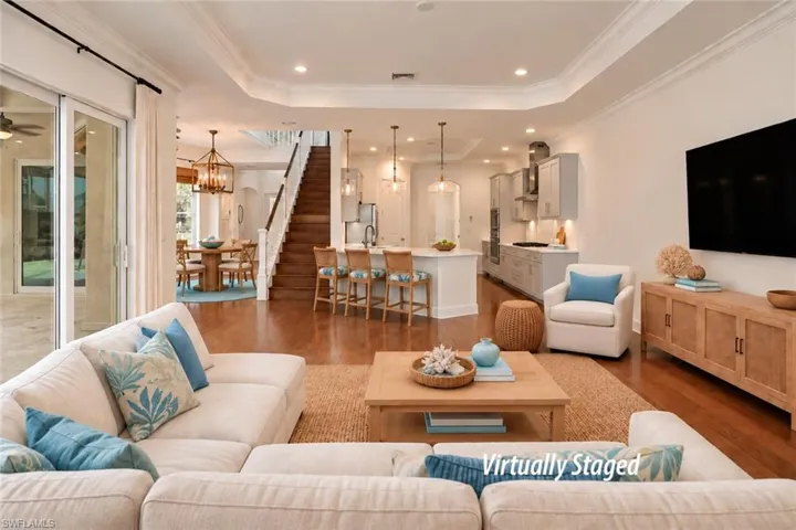 FAMILY ROOM.  STRIKING STAIRCASE TO UPPER LEVEL.  ARCHWAY AT MIDDLE REAR LEADS TO POWDER ROOM, LAUNDRY ROOM AND GARAGE.