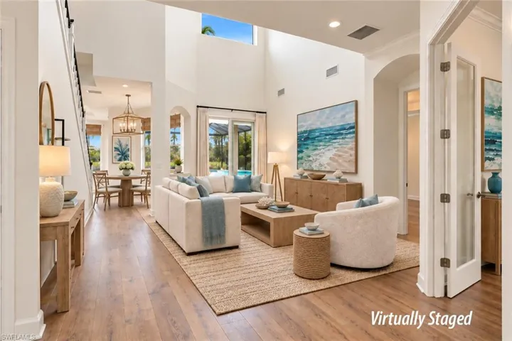 VIEW INTO LIVING AREA.  BREAKFAST NOOK SHOWN AT REAR.  DOOR TO RIGHT SIDE LEADS TO PRIMARY SUITE.  GLASS FRAMED DOOR LEADS TO DEN.