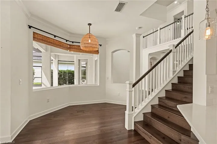 BREAKFAST NOOK AND STAIRS TO UPPER LEVEL ROOMS.  NOOK HAS CANTED WINDOWS.  ARCH TO RIGHT OF BREAKFAST NOOK ALLOWS SIGHT INTO THE LIVING ROOM.