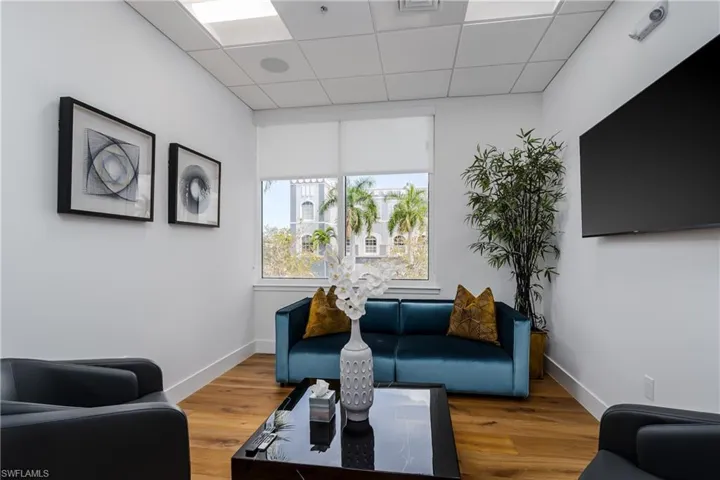 Interior room featuring wood-finish flooring and a drop ceiling with integrated lighting