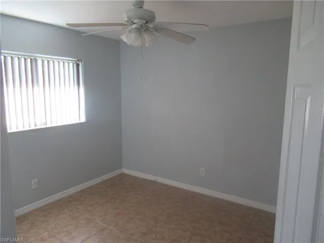 Tiled spare room with ceiling fan
