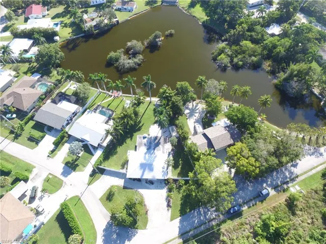 Aerial view of property and surrounding area with nearby suburban area and a large body of water