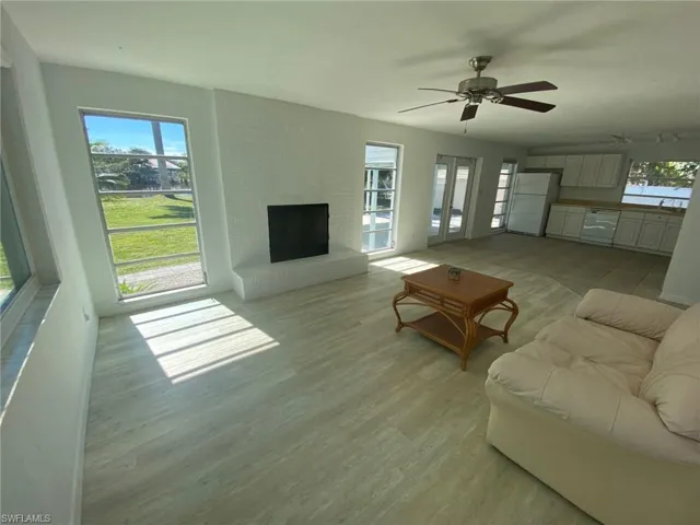 Living area featuring wood finished floors, a fireplace, and ceiling fan