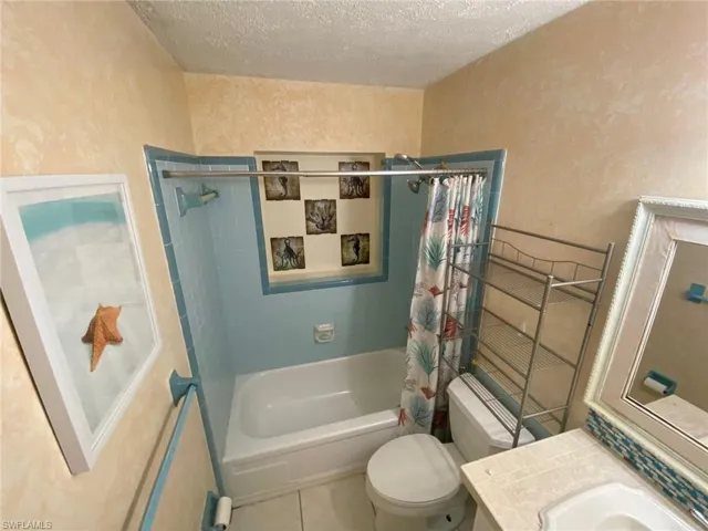 Empty room with light wood-style floors, a textured ceiling, ceiling fan, and a wall mounted AC