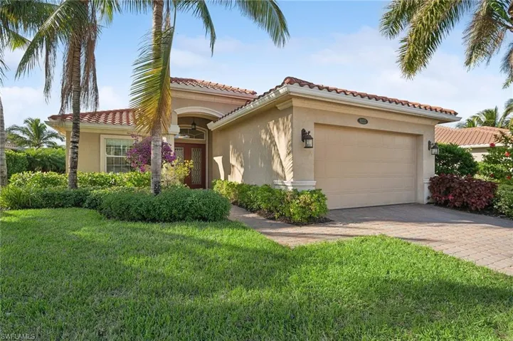 Mediterranean / spanish-style house with a garage and a front yard