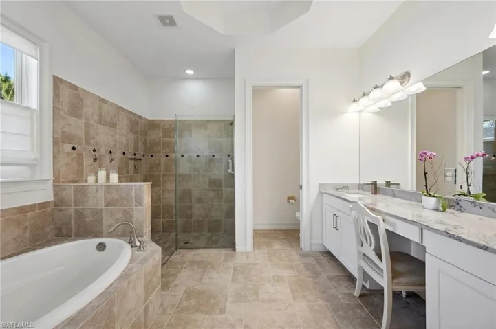 Full bathroom with vanity, toilet, and plus walk in shower