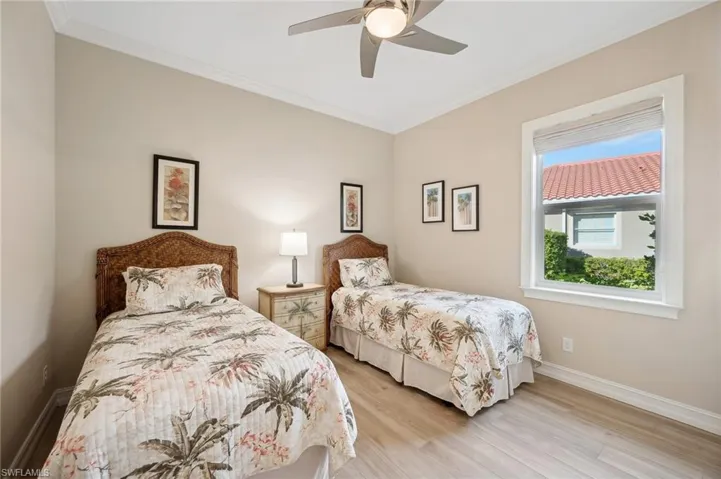 Bedroom with light hardwood / wood-style floors, ceiling fan, and crown molding