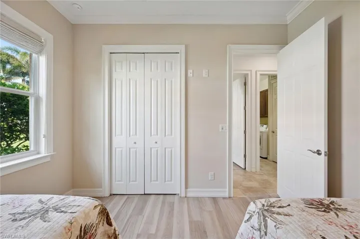 Bedroom with multiple windows, light hardwood / wood-style flooring, a closet, and ornamental molding
