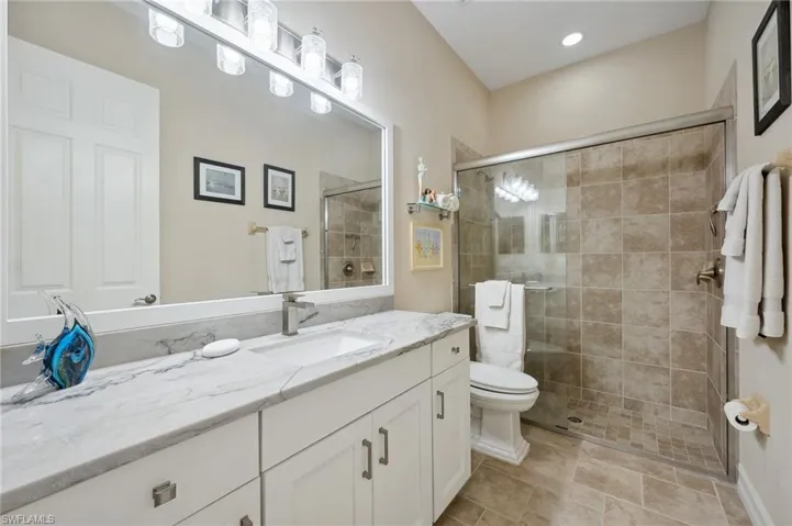 Bathroom featuring vanity, toilet, and walk in shower