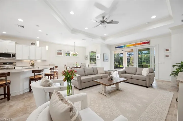 Living room featuring ceiling fan, french doors, crown molding, and a tray ceiling