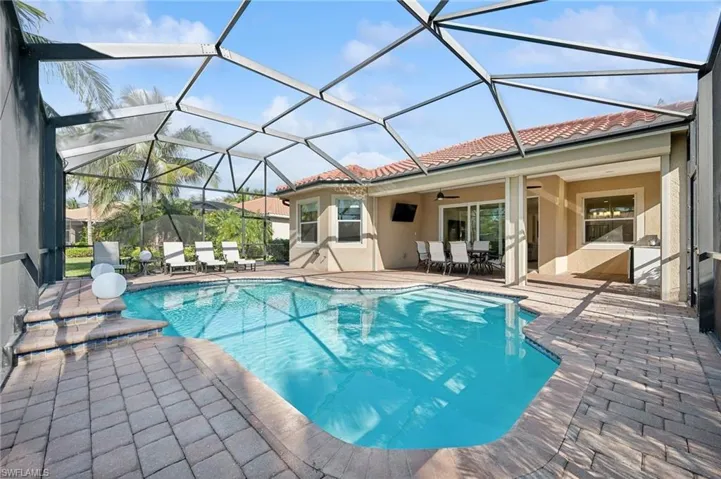 View of swimming pool featuring ceiling fan, a lanai, and a patio