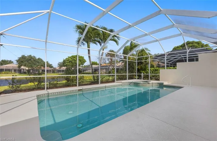 View of swimming pool featuring a patio area, glass enclosure, and an in ground hot tub