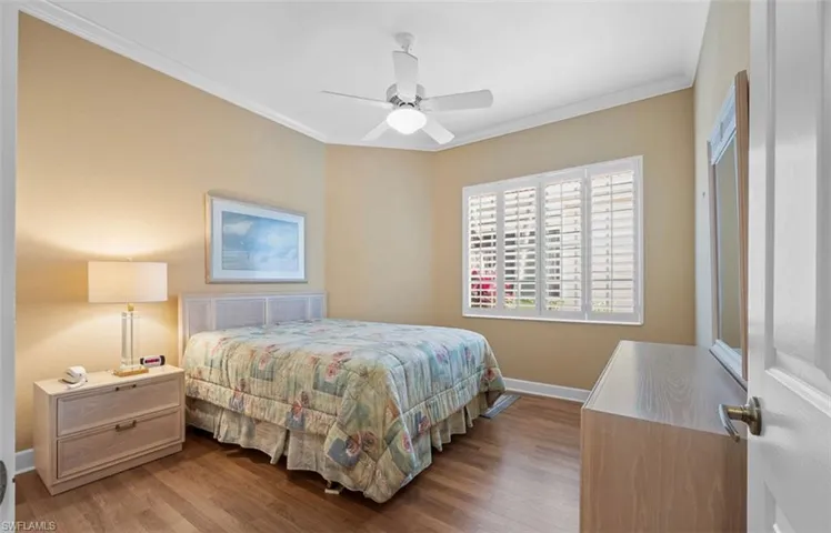 Bedroom with crown molding, ceiling fan, and hardwood / wood-style floors