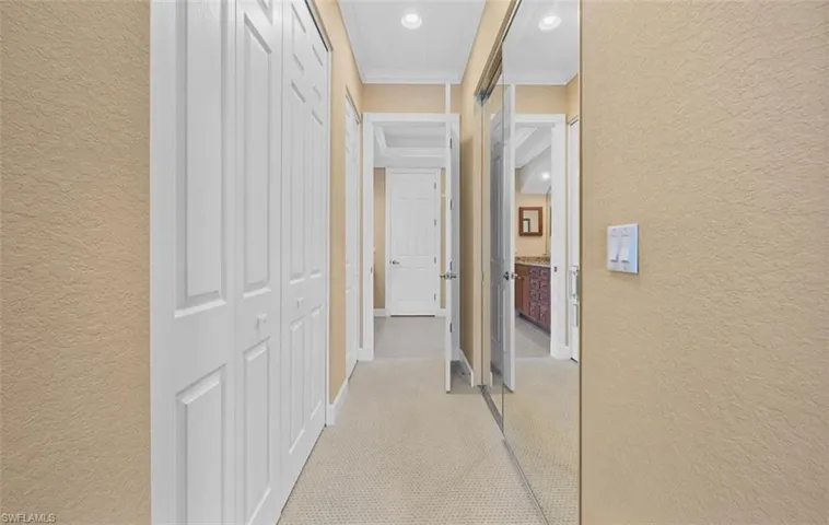 Hallway with ornamental molding and light carpet