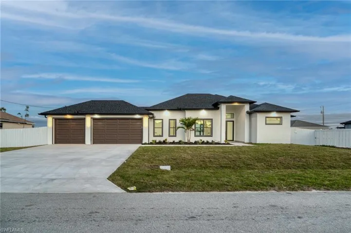 Prairie-style house with stucco siding, driveway, roof with shingles, and an attached garage