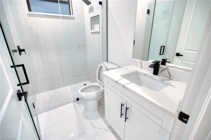 Full bath with a shower stall and vanity