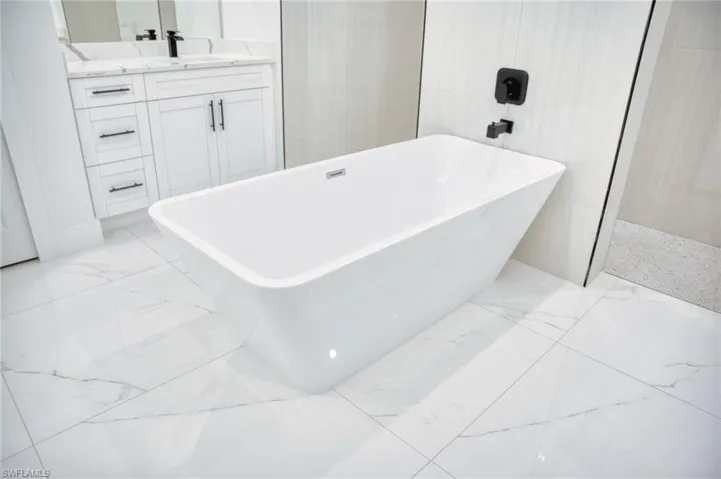 Full bath with vanity, a freestanding tub, and a walk in shower