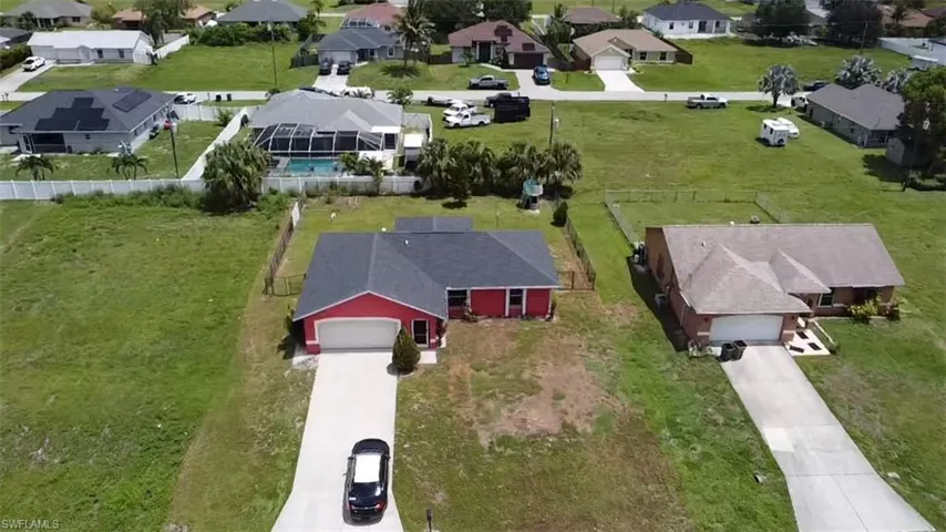 Red exterior with white garage door and dark shingle roof