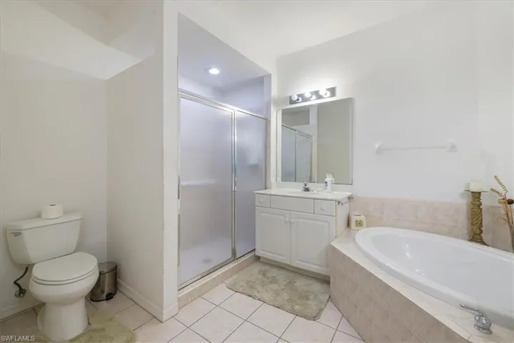 Bathroom with vanity, a stall shower, a bath, and light tile patterned floors