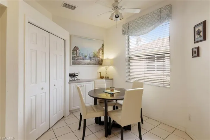Dining area with a ceiling fan and light tile patterned flooring