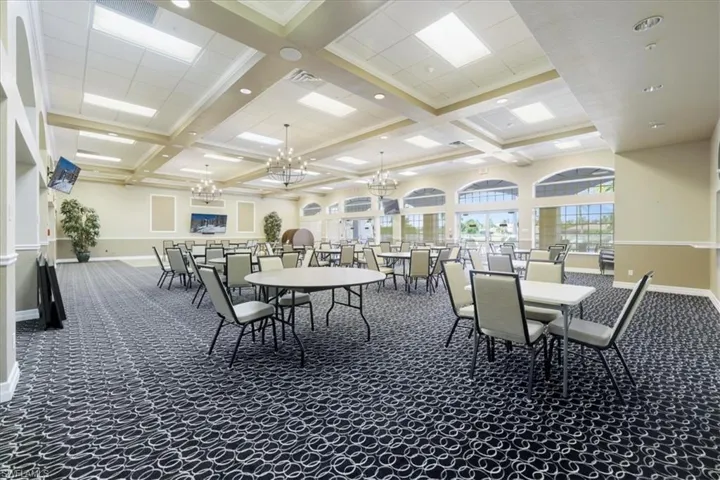 Dining room featuring dark colored carpet, coffered ceiling, and a chandelier