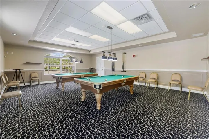 Rec room with a raised ceiling, billiards, wainscoting, and a decorative wall
