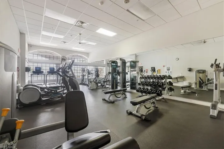 Gym with a paneled ceiling and a ceiling fan