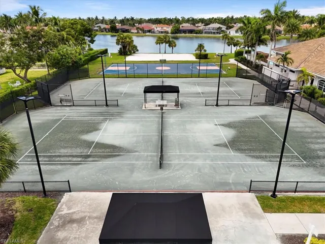 View of tennis court featuring a water view and a residential view