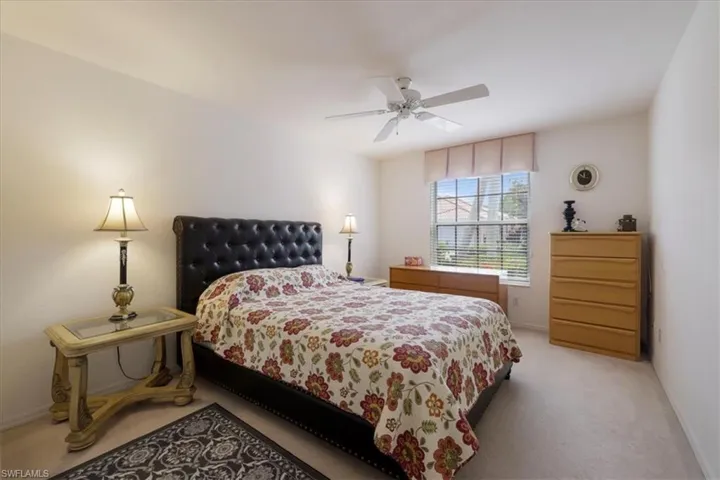 Carpeted bedroom featuring ceiling fan and baseboards