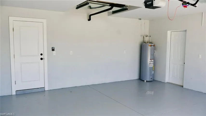 Garage featuring a garage door opener and water heater