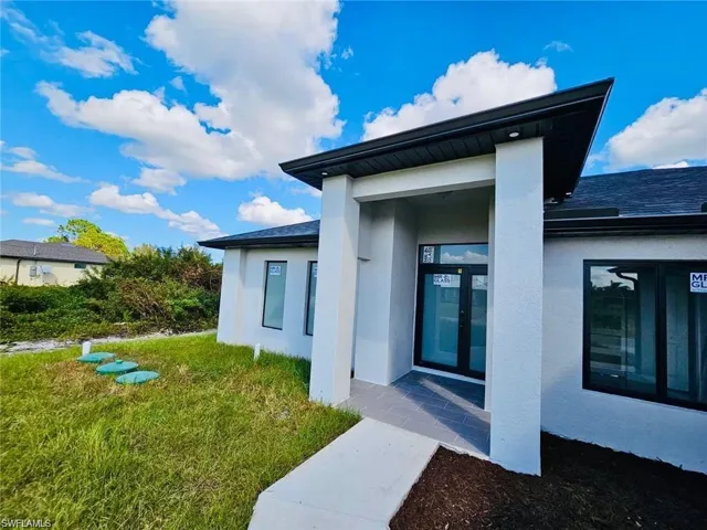 Doorway to property with a lawn