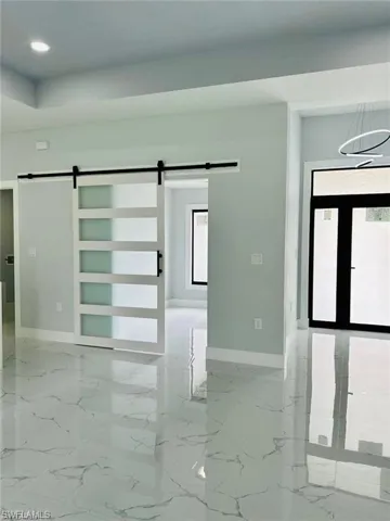 Empty room featuring a barn door and a wealth of natural light