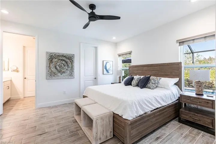 Bedroom with ceiling fan and ensuite bath and a lot of natural light.