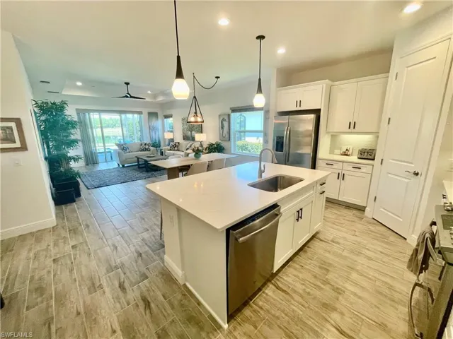 Kitchen featuring quartz counter tops,  a sink, dishwasher, white cabinets, ceramic plank floors, and stainless steel appliances
