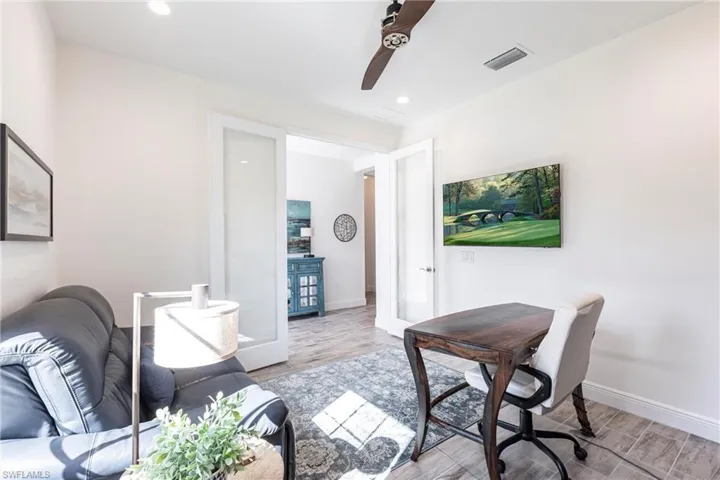Office with light hardwood / wood-style flooring and french doors
